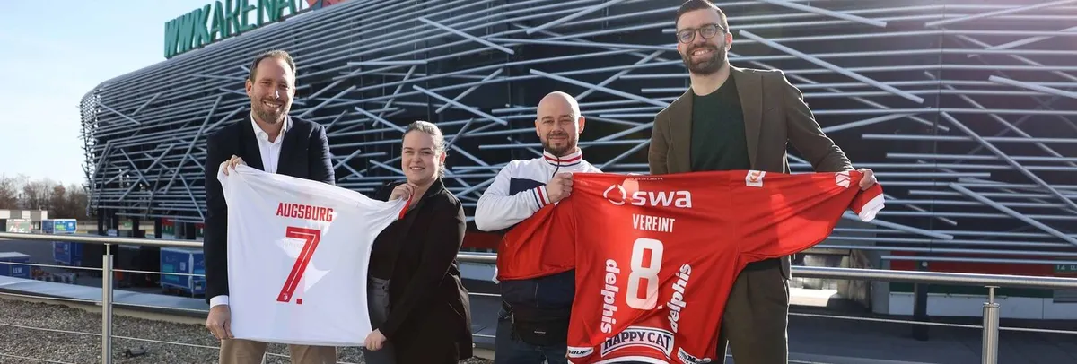 Offizielle der Augsburger Panther und des FC Augsburgs präsentieren Trikots der jeweiligen Vereine vor der WWK-Arena